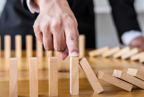 Wooden,Game,Strategy,,Businessman,Hand,Stopping,Falling,Wooden,Dominoes,Effect